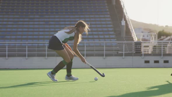 Female hockey players playing on the field