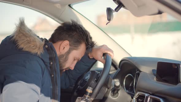 Drunken Driver Risk Car Accident. Man Holding Alcohol Bottle In Car. Dangerous On Road Drunk Driver.