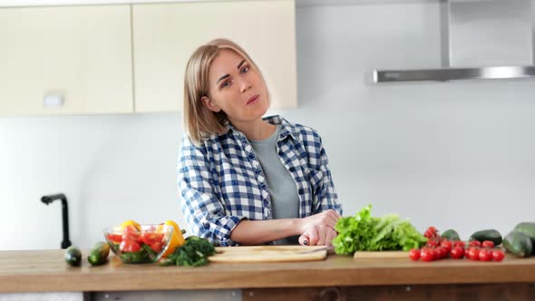 Pleasant Young Female Eating Fresh Organic Vegetables During Cooking Salad at Kitchen Medium Shot