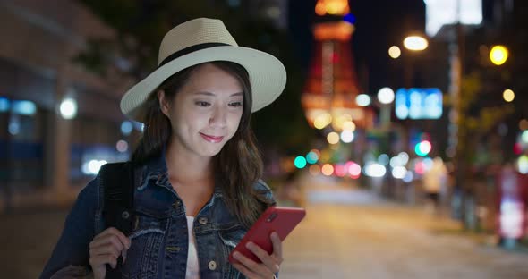 Woman use of mobile phone in Tokyo city at night