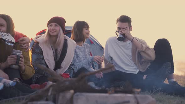 Tourists Drink Tea at Burning Bonfire in Evening Slow Motion