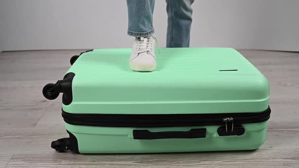 A Woman Does a Crash Test of a Plastic Suitcase