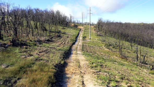 Aerial footage of a dirt track and telephone poles in regional Australia