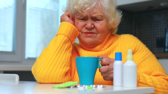 Ill Old Woman Taking a Pill From a Pill Dispenser in Her House