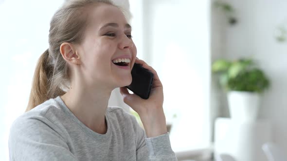 Young Woman Talking on Phone in Loft Workplace