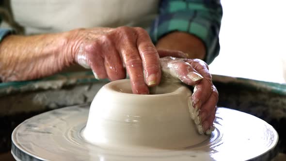 Mid-section of female potter making pot