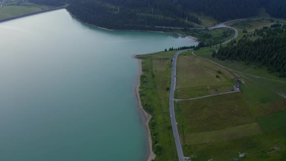 Asphalt Road At The Green Meadow Beside The Frumoasa Dam In Romania. aerial