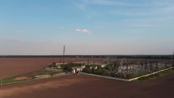 Quadrocopter flight over the power plant. Rows of poles, wires. City power station from above