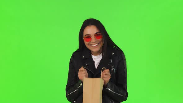 Beautiful Young Woman Looking Inside the Shopping Bag