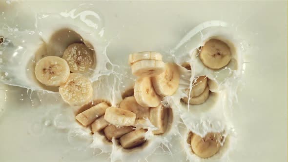 Pieces of Fresh Bananas Fall Into the Milk with Splashes