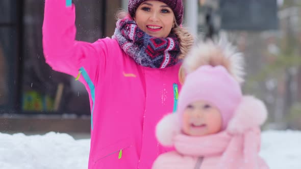 Woman Throws Snowball and Little Girl Kid Smiles