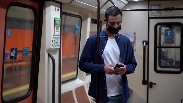 Anonymous passenger chatting on smartphone while commuting on subway