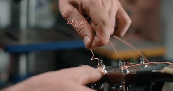 Guitar Tech Takes Off the Old Strings From the Guitar Tuners Changing the Strings on the Acoustic