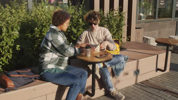 Two Students Eating Sandwiches Outside