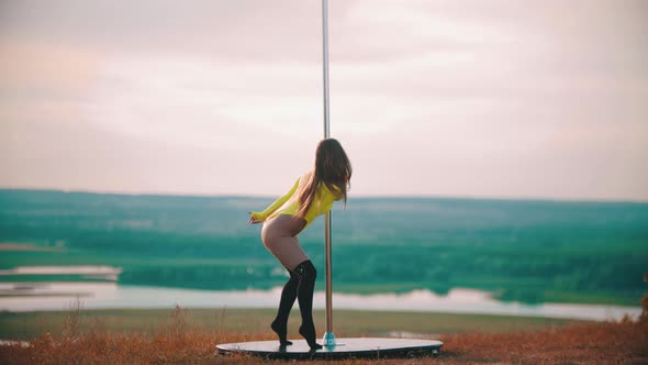 Woman in Yellow Swimsuit Dancing By the Pole