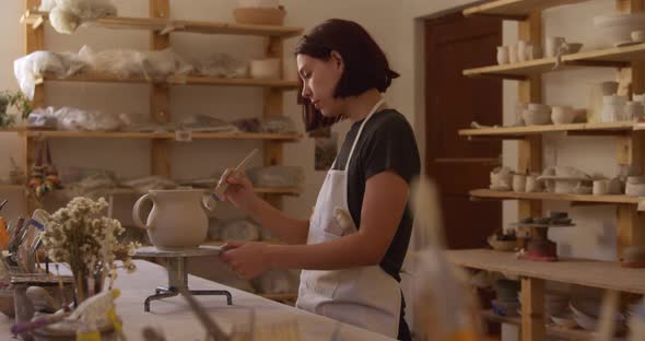 Young female potter working in her studio