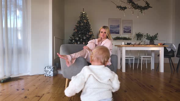 Mother's Christmas Mood with Her Child, Near the New Year Tree. Winter Holidays.