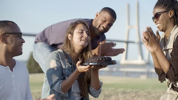 Smiling Woman with Long Hair Holding Cake with Sparkler.