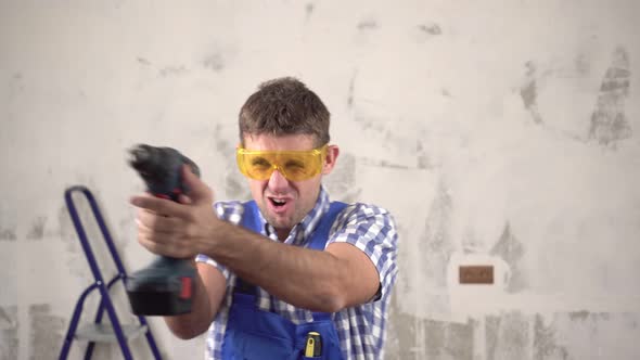 Funny Crazy Male Worker or Construction Worker with an Electric Screwdriver