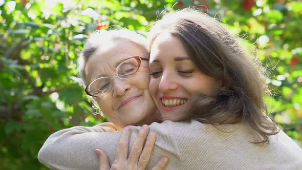 Happy Senior Mother in Eyeglasses is Hugging Her Adult Daughter the Women are Enjoying Together