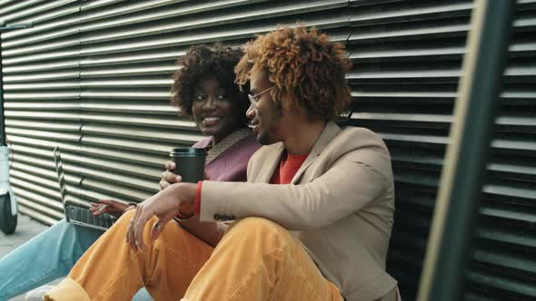 Afro Man and Woman Using Laptop and Talking on Street