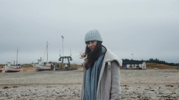 Portrait of Beautiful Happy Female Tourist in Winter Coat on Windy Low Tide Cold Baltic Sea Beach