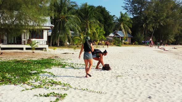 Women look beautiful on beautiful coast beach voyage by aqua blue ocean with clean sand background o