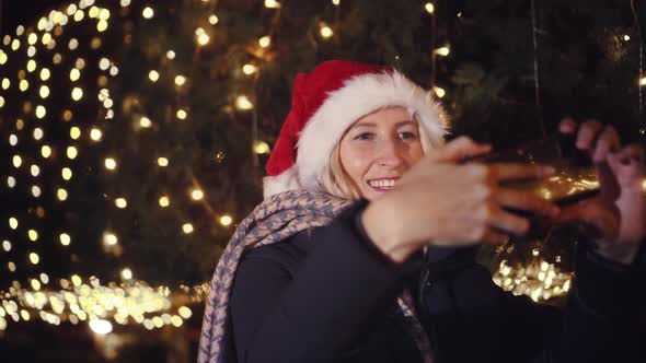 young beautiful blonde in Santa Claus hat, talking on video link in her phone