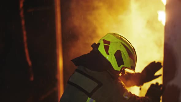 Fireman Breaking Through the Burned Door. Slow Motion Shot