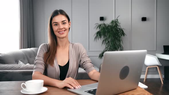 Portrait of Freelancer Woman Posing in Front of Desk with Laptop