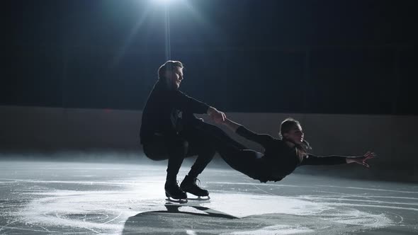 Pair Figure Skating Training Strong Sportsmen is Holding His Female Partner and Spinning on Ice Rink