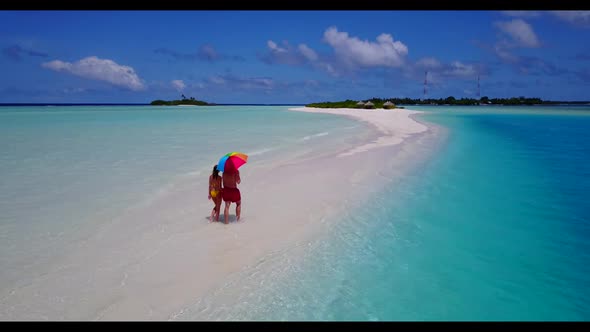 Young couple happy together on exotic lagoon beach trip by transparent water and white sand backgrou