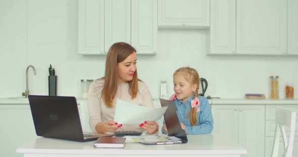 Positive Mother Calculating Bills with Daughter