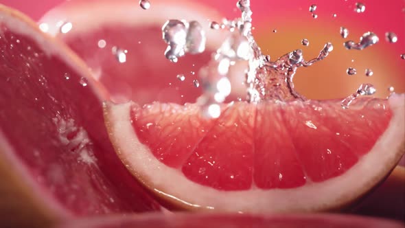 Slow Motion Shot of Grapefruit Water Splashing Through Grapefruit Slices