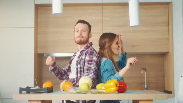 A Happy Man and Woman are Dancing Listening Music and Enjoying Improvised Party at Home Kitchen Fun