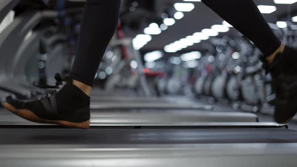 Closeup of Legs Man Jogging on Treadmill in Gym