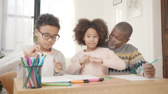 Cute Happy African American Boy and Girl Drawing with Colorful Pencils Exercising Together with