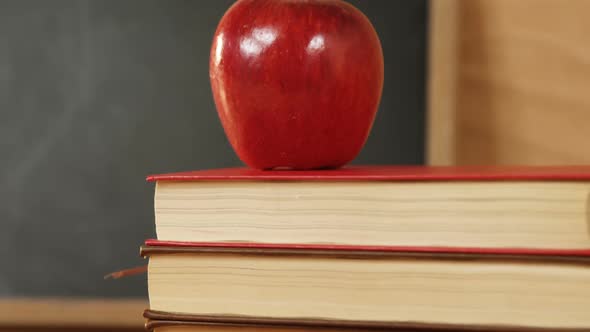 Close-up of books stack with red apple