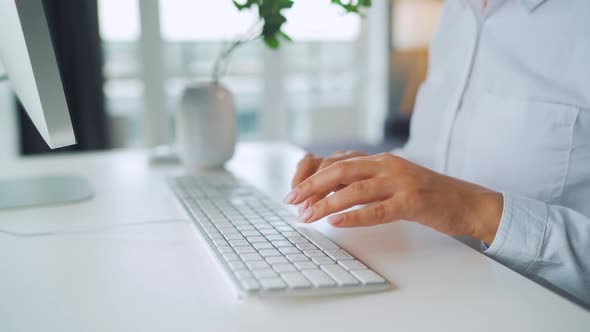 Woman with Glasses Typing on a Computer Keyboard. Concept of Remote Work.