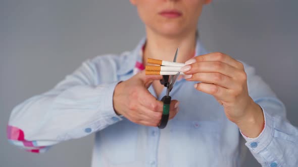 Quit Smoking Concept, Woman Cuts Cigarettes with Scissors.