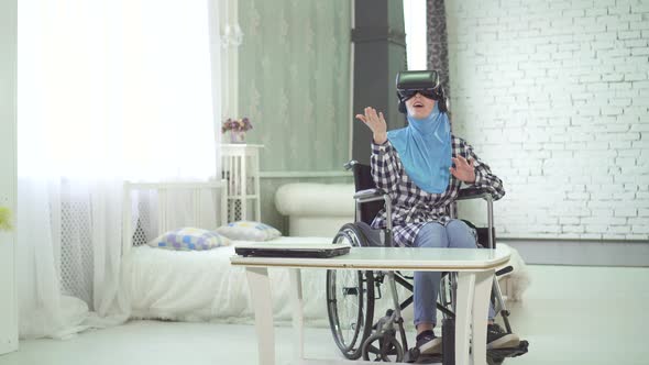 Woman in Hijab  Wheelchair Uses VR Glasses 3D Technology Virtual Travel