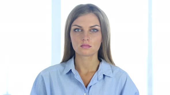 Serious Young Woman Looking at Camera in Office