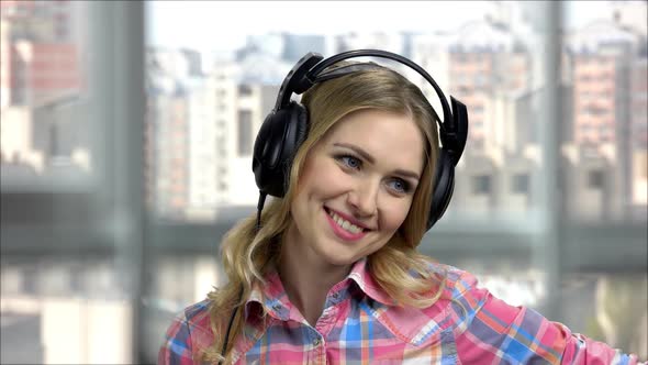 Portrait of Young Happy Woman Wearing Headphones and Talking