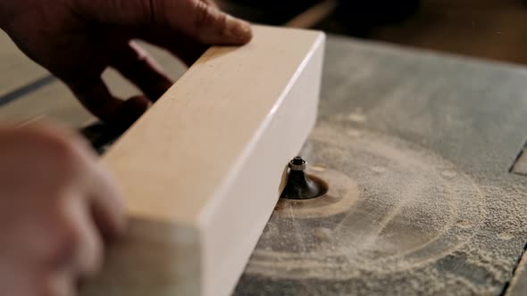 Woodworker handles wood in an old workshop on a milling machine. Craft factory authentic. 