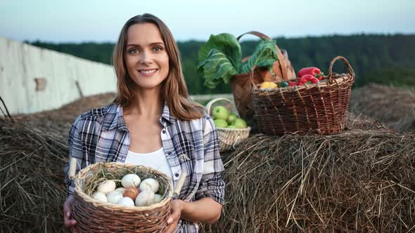 Portrait of Woman Posing with Basket of Organic Chicken Eggs and Vegetables