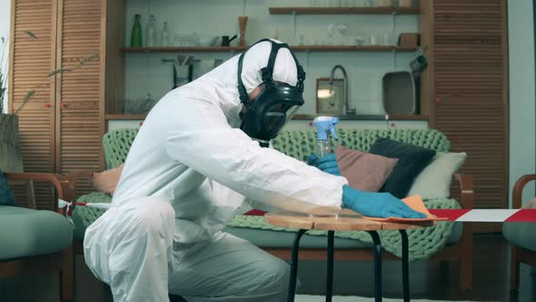 A Disinfector Sanitizes Table with Antiseptic in Room