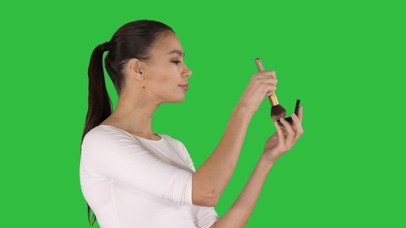 Young Beautiful Woman Applying Powder on Cheek with Brush