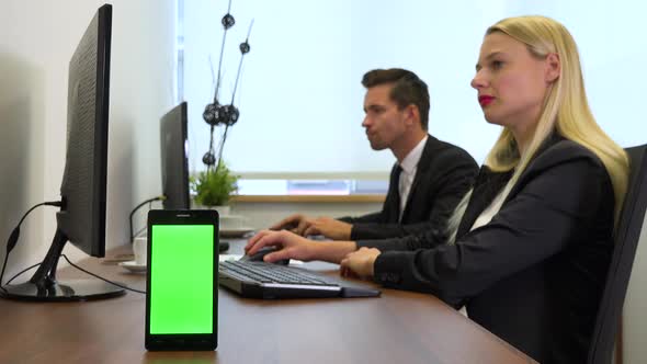 Two Office Workers, Man and Woman, Work on Computers