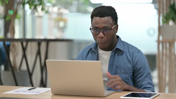 Successful Young African Man Celebrating on Laptop