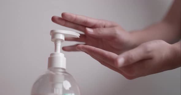 Close up human hands press on pump gel bottle